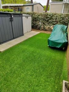 a yard with a green lawn with a tarp on it at Bienvenue chez Diamina et Patrick in La Tremblade
