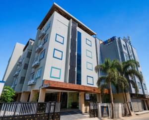 a building with palm trees in front of it at Indie Stays Studio Kharadi in Pune