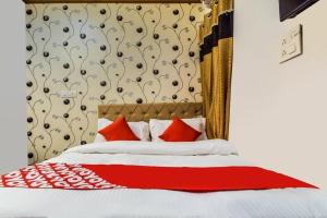 a bedroom with a bed with red and white pillows at Hotel Amrapali UDAIPUR BEST GORUP BOOKING HOTEL NEAR CA CIRCLE in Udaipur