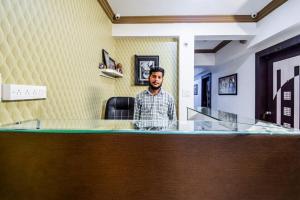 a man standing behind a counter in a office at Hotel Amrapali UDAIPUR BEST GORUP BOOKING HOTEL NEAR CA CIRCLE in Udaipur