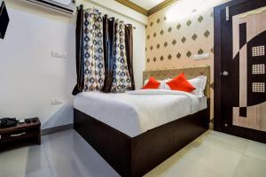 a bedroom with a bed with red pillows on it at Hotel Amrapali UDAIPUR BEST GORUP BOOKING HOTEL NEAR CA CIRCLE in Udaipur