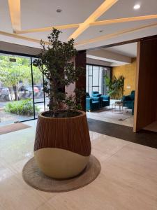 a large pot with a tree in the middle of a lobby at FarGo Hotels By Lowfare Hotels in Bangalore
