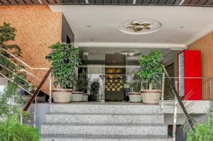 a staircase with potted plants in a building at Hotel Aarambh By Ramayana Grand-Near Ram Mandir Ayodhya in Ayodhya