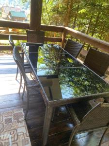 a glass table and chairs sitting on a deck at Подих Лісу 2 in Synevyrsʼka Polyana
