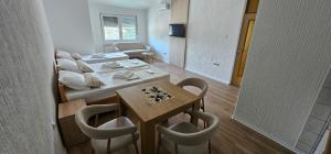 a room with a bed and a table and chairs at Apartments AS Dubrave in Dubrave Gornje