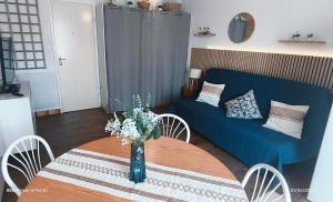 a living room with a blue couch and a table at Studio 4 personnes au Cap-d'Agde in Agde