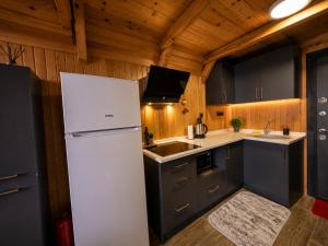 a kitchen with a white refrigerator and a sink at Aurora Suit Bungalov in Rize