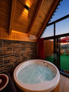 a large bath tub in a room with a large window at Aurora Suit Bungalov in Rize