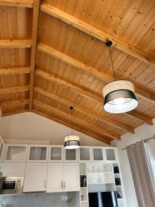 a kitchen with wooden ceilings and two lights at Nōema Residences I in Nafpaktos