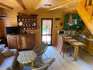 a living room with a table and chairs in a cabin at Domek letniskowy Fuleda in Fuleda +18 photos