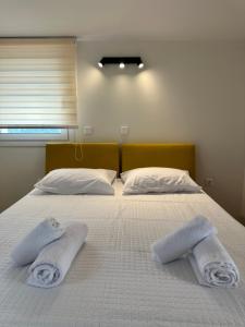a bed with two towels on top of it at Nōema Residences I in Nafpaktos