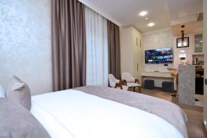 a hotel room with a white bed and a living room at Nord Gate Avenue Hotel in Yerevan