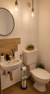 a bathroom with a white toilet and a sink at Hanga Apartman in Băile Tuşnad