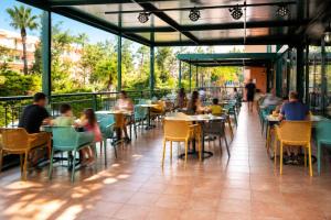 a group of people sitting at tables in a restaurant at Aparthotel SunClub Salou in Salou