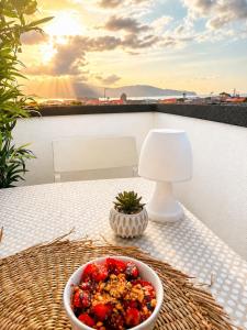 a bowl of fruit on a table with a lamp at Welcome Pico in Madalena