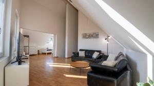 a living room with a couch and a table at Swiss Suites Oberglatt in Oberglatt