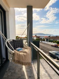 a hammock on a balcony with a view of a street at Welcome Pico in Madalena