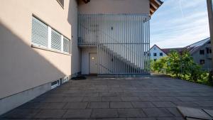 an empty courtyard of a building with a stairway at Swiss Suites Oberglatt in Oberglatt