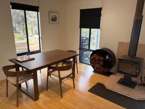 a dining room with a table and a fireplace at Kalamata - Adults Only Country Escape in Boyup Brook