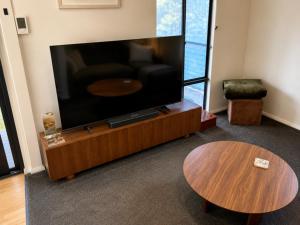 a living room with a flat screen tv and a table at Kalamata - Adults Only Country Escape in Boyup Brook
