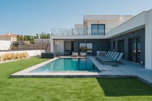 a backyard with a swimming pool and a house at Villa Locki with jacuzzi, private pool and sea view in Lourinhã