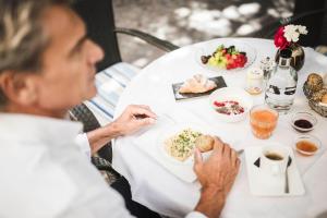 a woman sitting at a table eating food at Romantik Hotel & Restaurant Stafler in Vipiteno +170 photos