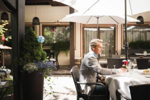 a man sitting at a table in a restaurant at Romantik Hotel & Restaurant Stafler in Vipiteno