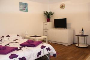 a bedroom with a bed and a flat screen tv at Apartman Renata in Biograd na Moru