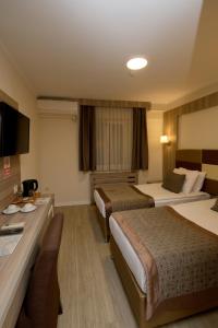a hotel room with two beds and a desk at Pera Arya Hotel in Istanbul +132 photos