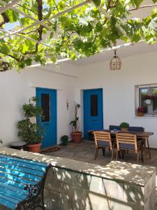 a patio with a table and chairs and blue doors at Kampos Family Garden in Batsi