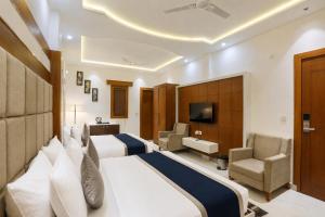 a hotel room with two beds and a television at Signature StayZ - Amar Singh Palace Near Taj Mahal in Agra