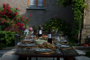 a wooden table with wine glasses and food on it at Milorava's Guest House & Wine Cellar in Telavi