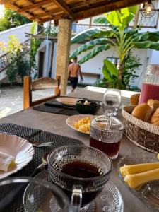 a table with plates of food and a glass of wine at Maré alta in Guriú