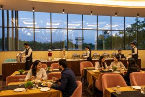 a group of people sitting at tables in a restaurant at Signature StayZ - Amar Singh Palace Near Taj Mahal in Agra