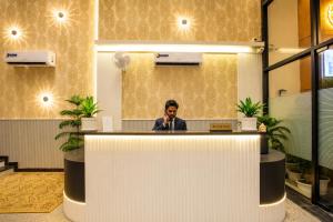 a man sitting at a counter talking on a microphone at Signature StayZ - Amar Singh Palace Near Taj Mahal in Agra