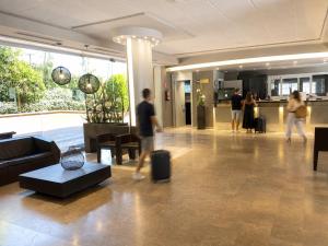a group of people walking in a lobby with luggage at Aparthotel SunClub Salou in Salou