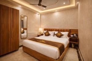 a bedroom with a large bed and a mirror at Signature StayZ - Amar Singh Palace Near Taj Mahal in Agra +16 photos