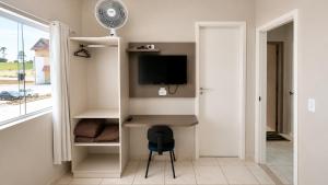a room with a desk with a tv and a window at Hotel Goedert in Major Vieira