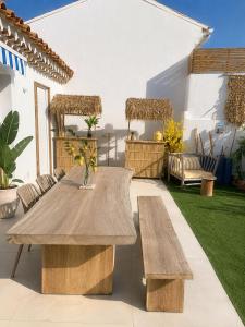 a patio with a wooden table and benches at Villa Boho Cassis in Cassis