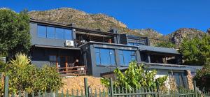 a house with a mountain in the background at Apex Ocean and Mountainview in Gordonʼs Bay