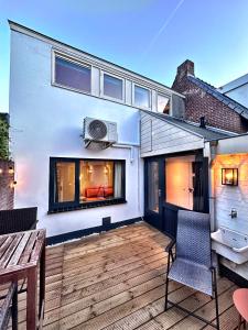 a balcony of a house with a wooden deck at Barefoot Cottage in Noordwijk