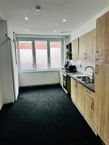 a kitchen with wooden cabinets and a large window at Echappée Rétro in Frameries