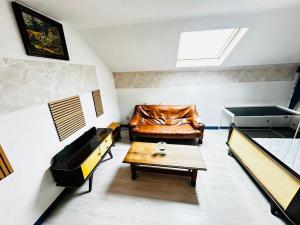 a living room with a leather couch and a table at Echappée Rétro in Frameries
