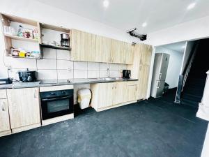 a kitchen with wooden cabinets in a room at Echappée Rétro in Frameries