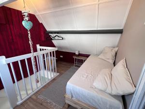 a small bedroom with a bed and a crib at Barefoot Cottage in Noordwijk