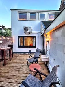 a patio with chairs and a table on a building at Barefoot Cottage in Noordwijk