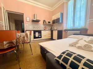 a bedroom with a large bed and a kitchen at La Gardenia del ducato in Parma