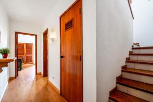 a hallway with stairs and a wooden door at Bellavista Avenida By BeGuest in Albufeira