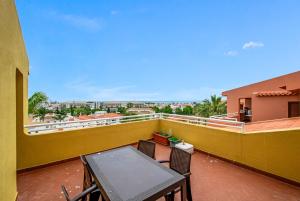 a balcony with a table and chairs on a yellow wall at Bellavista Avenida By BeGuest in Albufeira