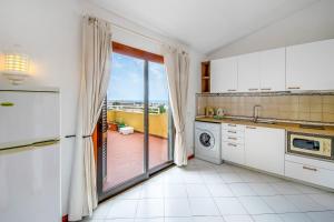 a kitchen with a view of a balcony at Bellavista Avenida By BeGuest in Albufeira +136 photos